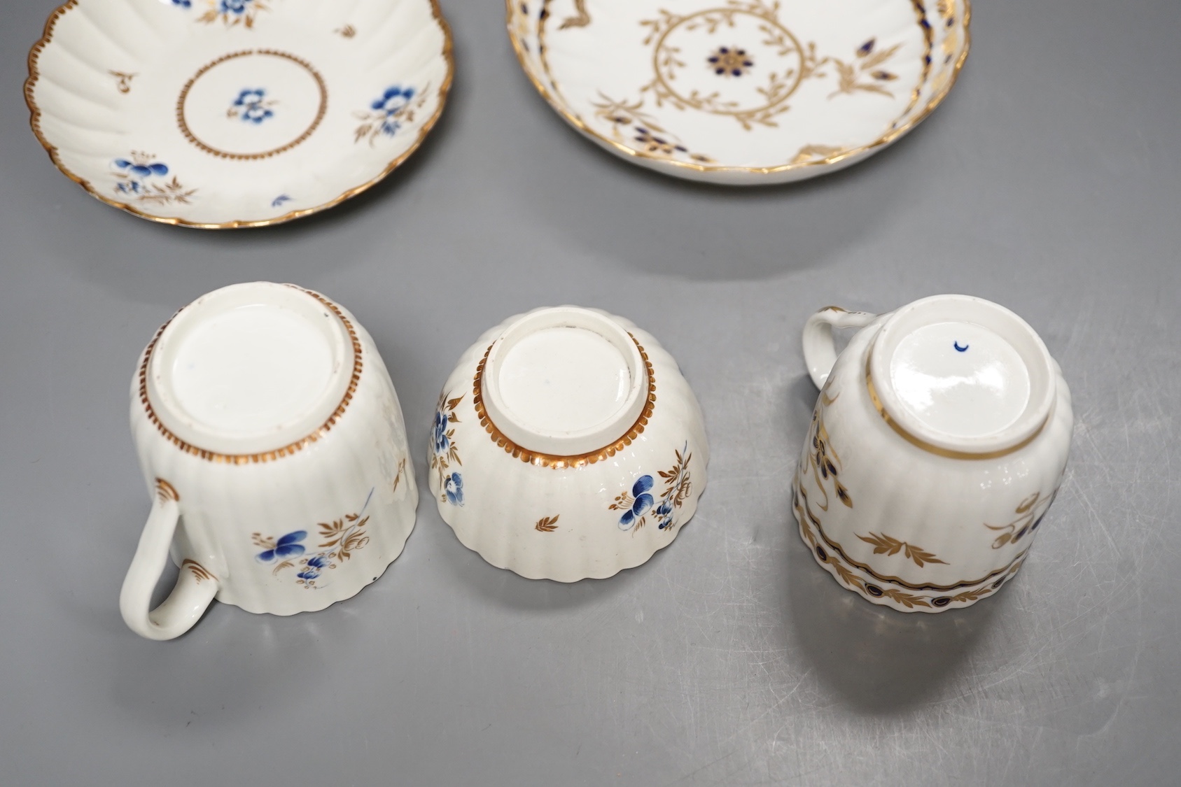 A Worcester fluted coffee cup, teacup and saucer painted with dry blue flowers and gilt foliage and a fluted coffee cup and saucer with blue and gilt decoration c.1775 and later